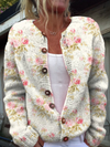 Elegant strikket ullgenser med friske rosa blomster og grønne blader samt knapper for en sofistikert og frisk stil